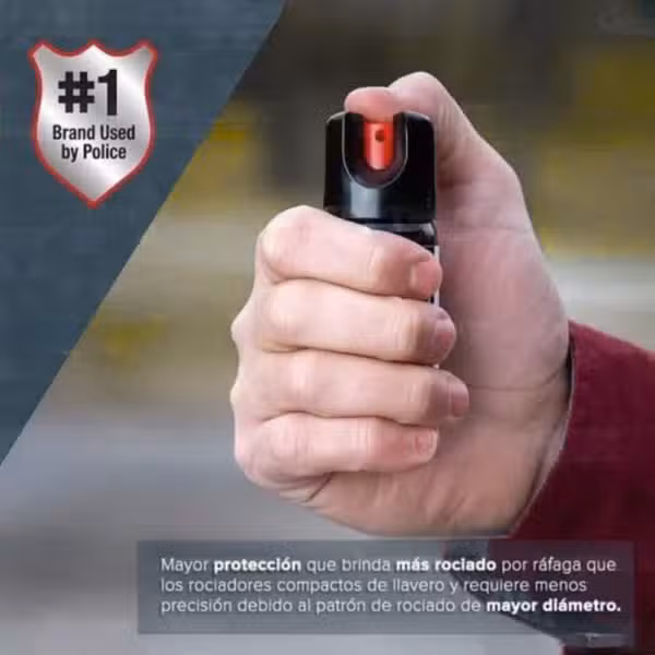 Gas pimienta SABRE RED de 45 g sostenido en una mano para mostrar su tamaño.